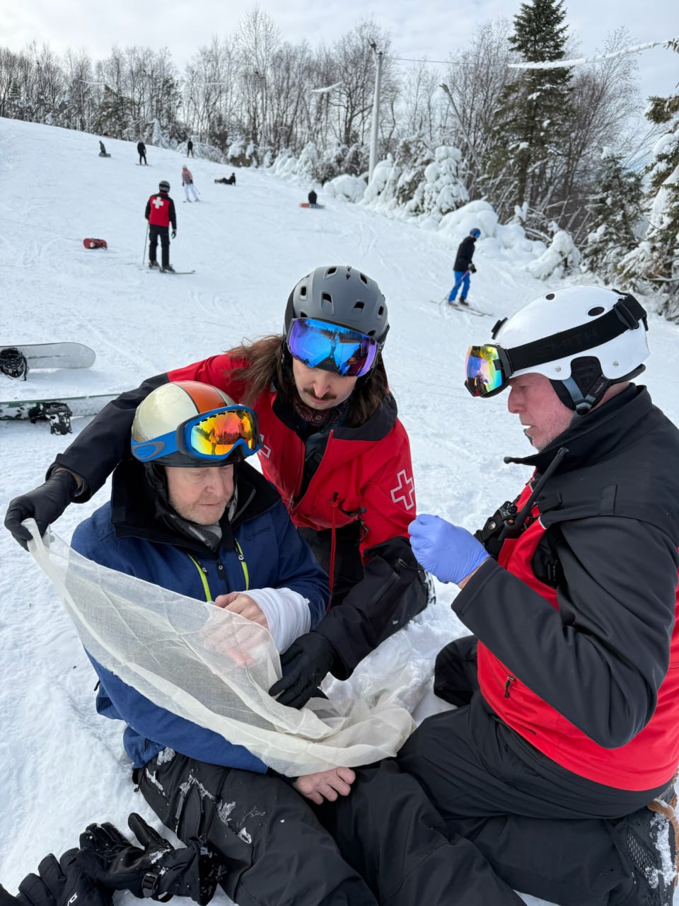 Charlie Szoradi being helped by ski patrol after breaking his wrist snowboarding