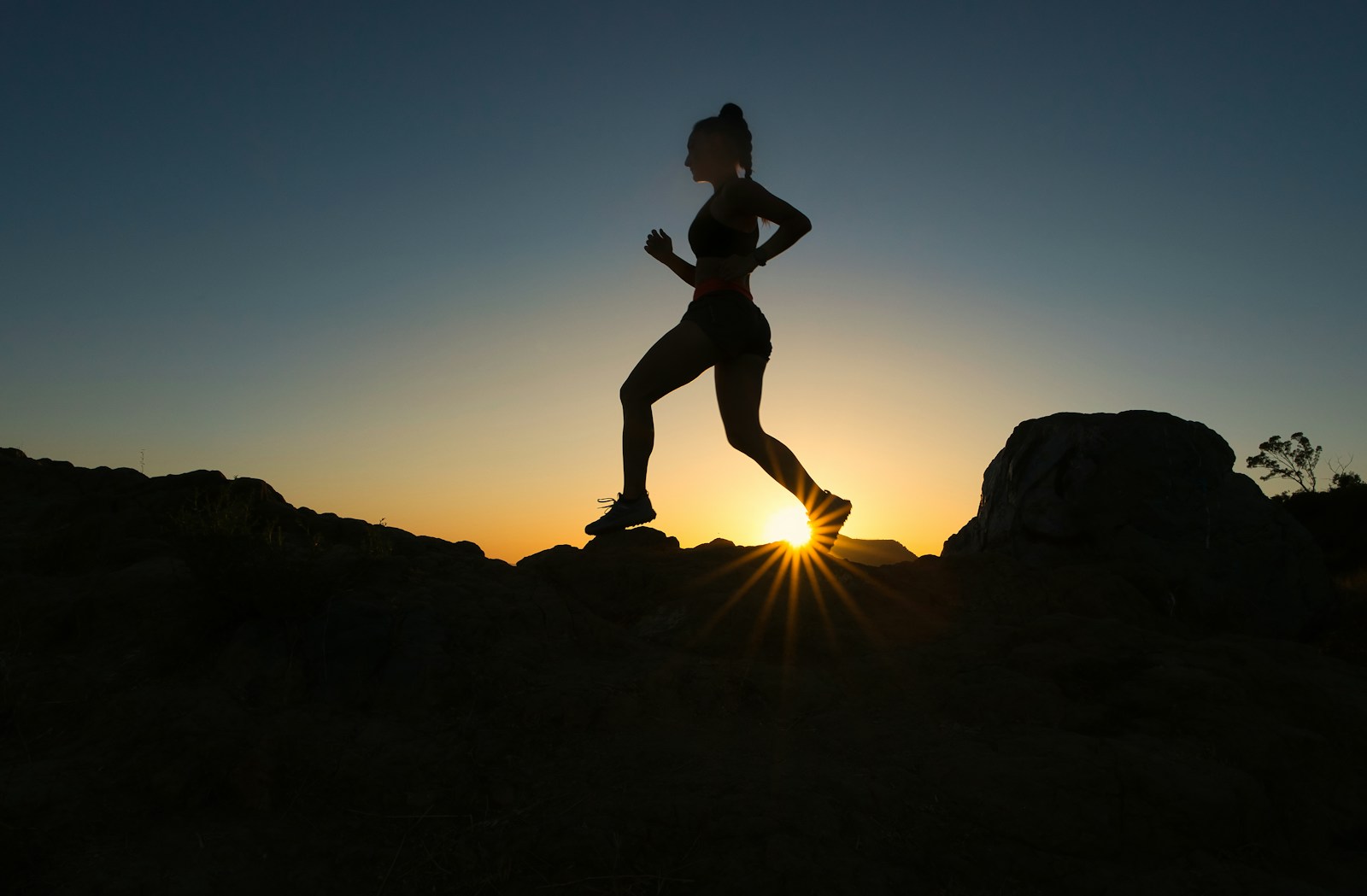 Silhouette of a woman running at sunset representing how kale's potassium, magnesium, vitamin C, and antioxidants help your body withstand summer heat exhaustion