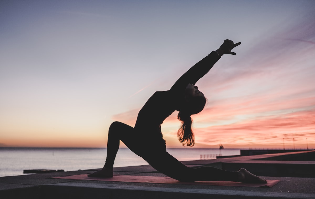 Woman doing yoga outdoors in sunshine